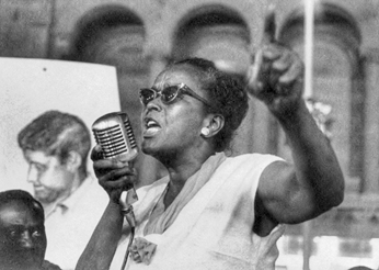 Ella Baker speaks impassioned into a microphone.