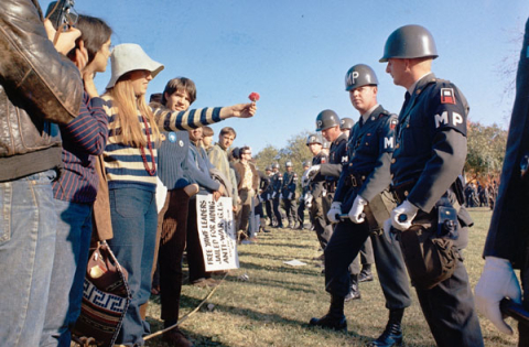 Anti-war demonstator offering a flower to a military policeman