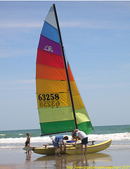 Small boat with multi-colored sail on Holden beach.