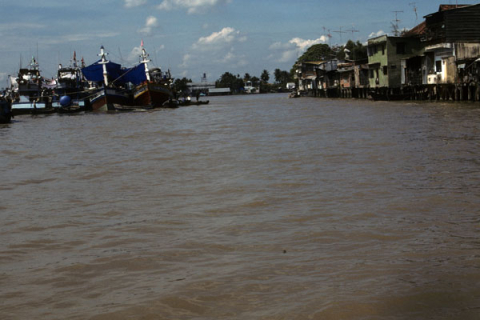 Moored ships and waterside homes on Mekong River at Mytho
