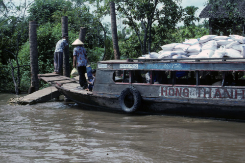 River boat with cargo sacks on top moored in Mekong River near Mytho